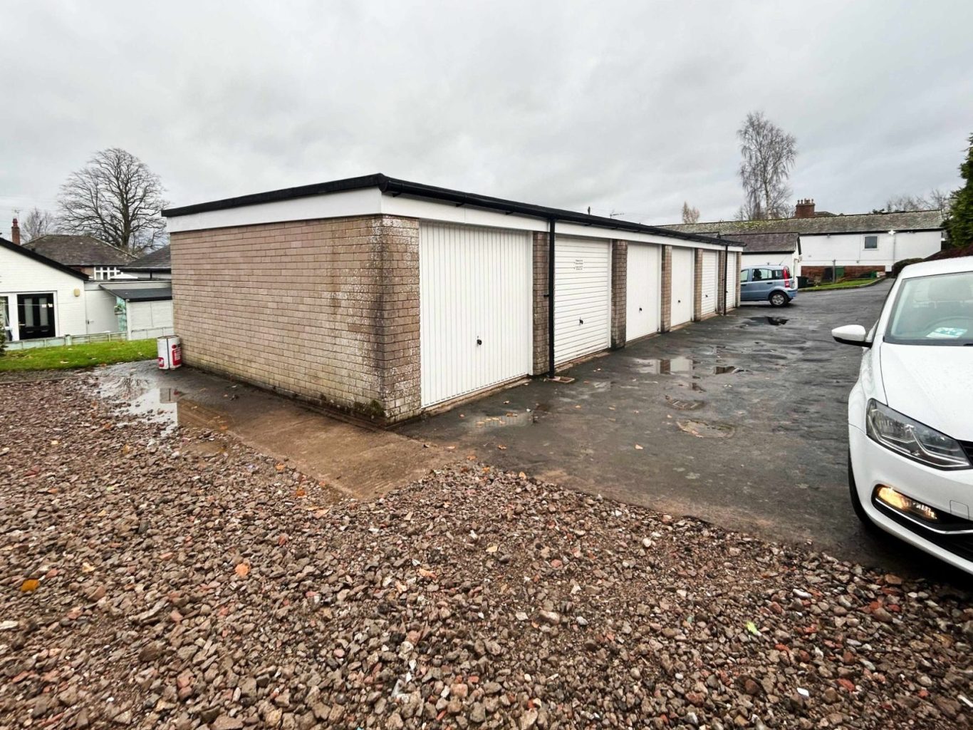 a car park adjacent to a row of lock up garages